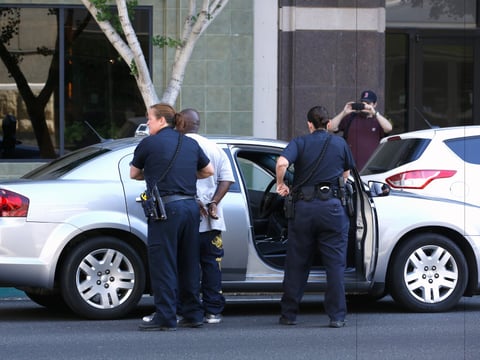 In this photo file photo taken Wednesday June 24, 2015, a citizen, right, records Sacramento Police officers taking a suspect into custody who was stopped in what police say was a car that was reported stolen, in Sacramento, Calif. 
